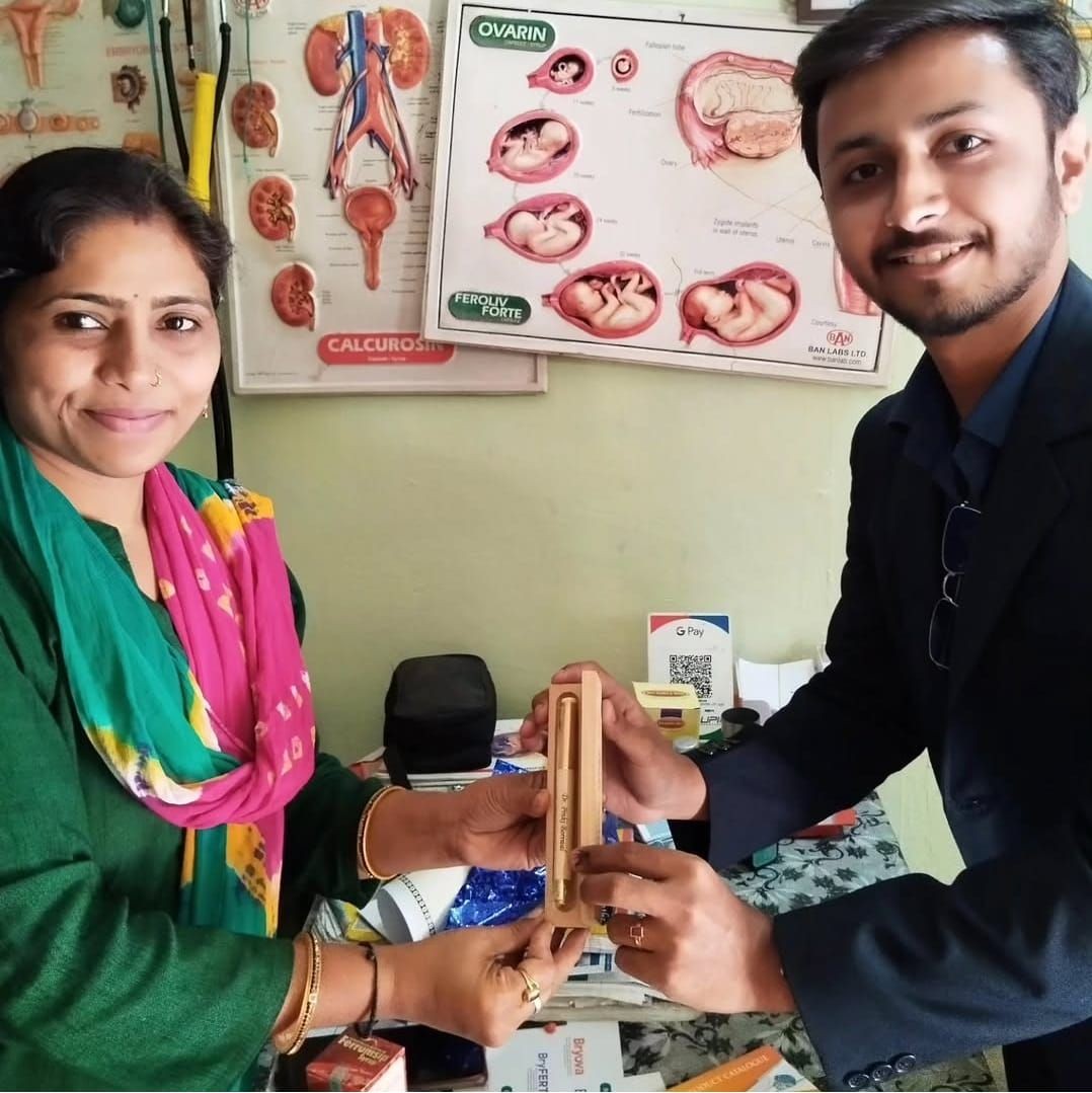 Two people holding a medical instrument in a clinic with anatomical posters on the wall.